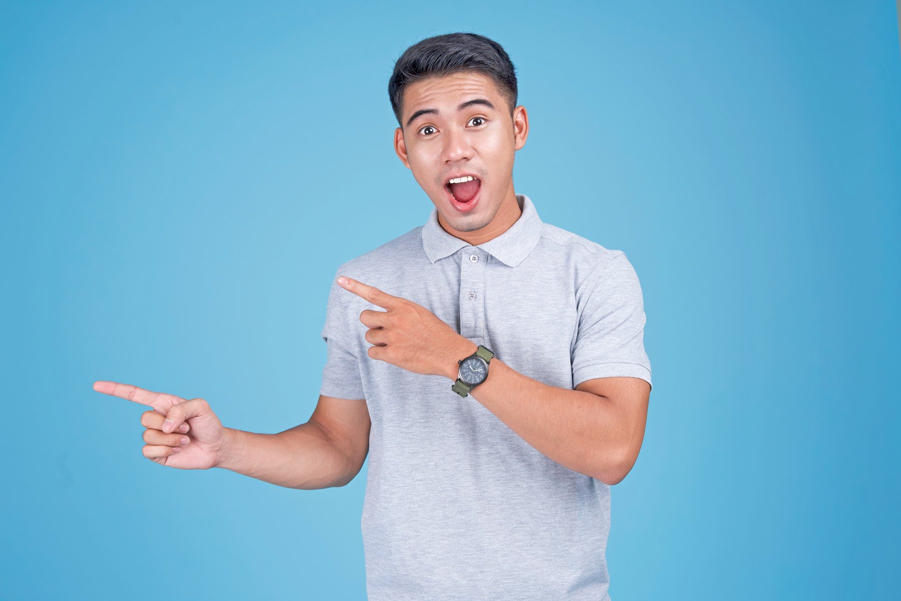 Man Gesturing and Pointing to the Left on Blue Background